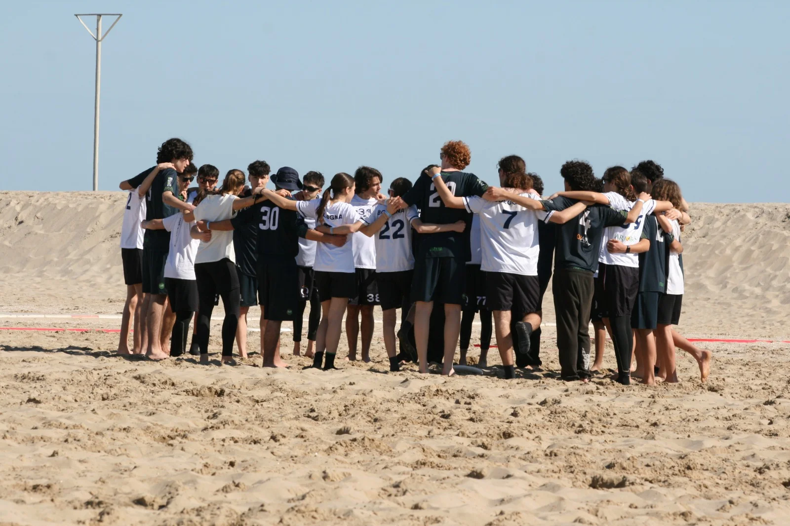 Giocatrici e giocatori abbracciati in cerchio sulla spiaggia al Paganello 2026